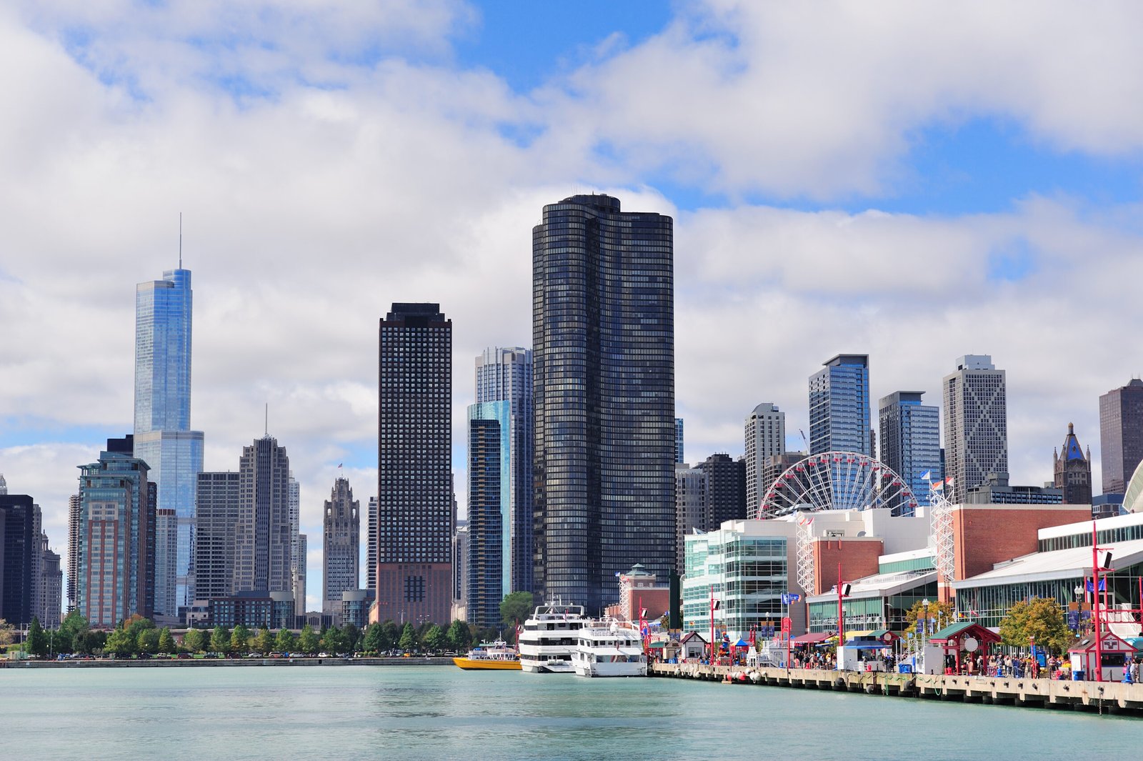 Chicago city downtown urban skyline with skyscrapers over Lake Michigan with cloudy blue sky.